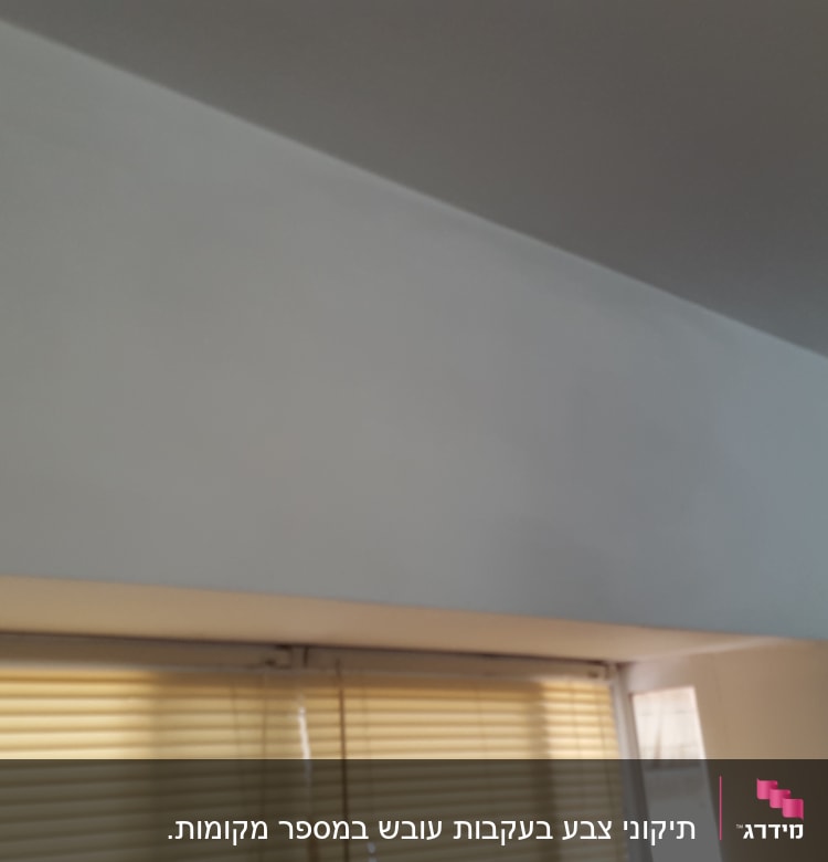 קיר צבוע בלבן ליד חלון עם תריסים